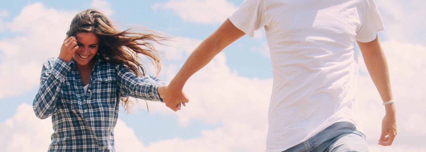 O fată fericită ținând mâna iubitului O fată fericită ținând mâna iubitului